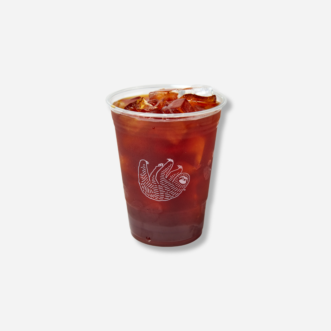 A clear plastic cup filled with iced coffee and ice cubes, with the Bean & Bean sloth logo printed on the front.
