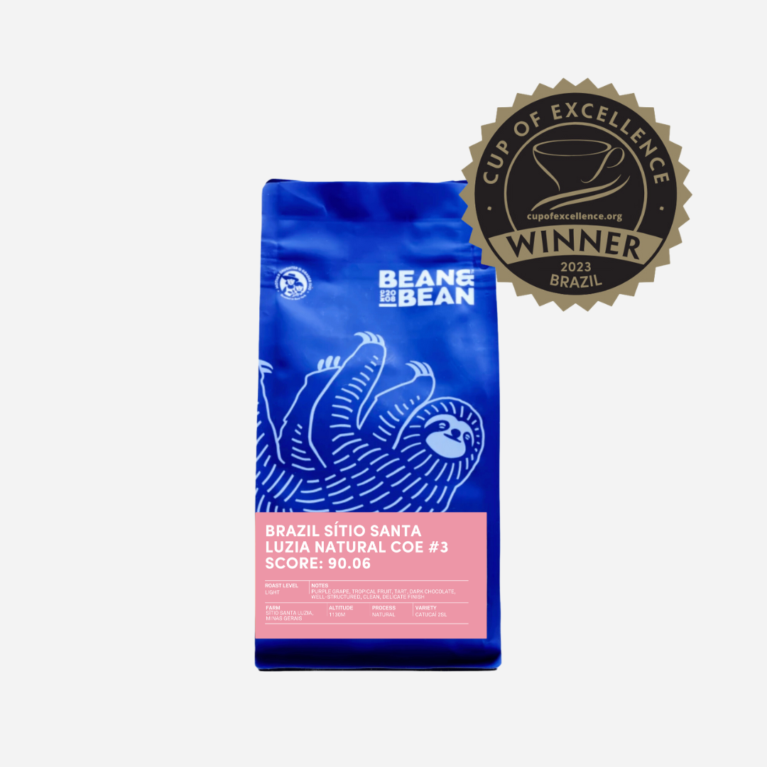 Purple "Bean & Bean Coffee Roasters" bag with a colored label that says Brazil Cup of Excellence #3 Natural [Score 90.06]