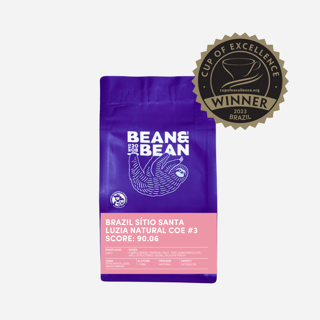 Purple "Bean & Bean Coffee Roasters" bag with a colored label that says Brazil Cup of Excellence #3 Natural [Score 90.06]