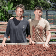 Father and son portrait with coffee cherries on drying bed