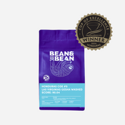 Purple "Bean & Bean Coffee Roasters" bag with a colored label that says Honduras Cup of Excellence #5 Gesha Washed [Score 90.04]