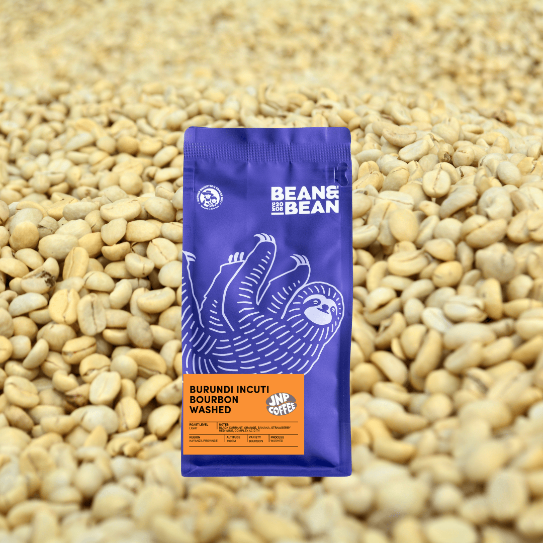 A Bean & Bean bag of Burundi Incuti Bourbon Washed against a background of dried coffee beans.