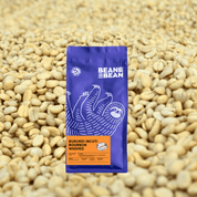 A Bean & Bean bag of Burundi Incuti Bourbon Washed against a background of dried coffee beans.