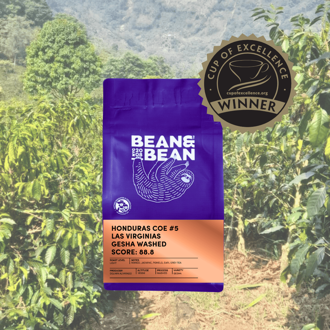 Purple Bean & Bean coffee bag labeled “Honduras COE #5 Las Virginias Gesha Washed” with tasting notes of mango, jasmine, pomelo, and earl grey tea, shown against a lush coffee farm backdrop with a Cup of Excellence winner badge.