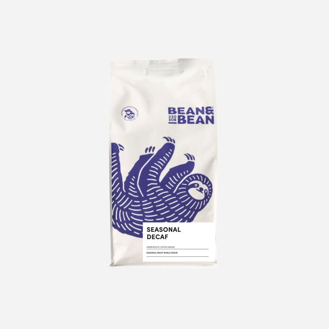 White coffee bag with a purple sloth illustration. The label reads 'Bean & Bean Seasonal Decaf